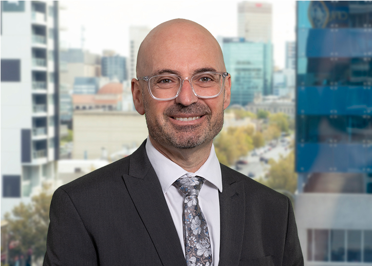 A photo of Steve Fimmano looking straight ahead with a view of Adelaide in the background