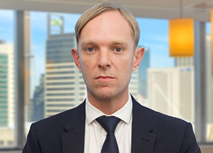 A photo of Pieter Klopper looking straight ahead with a view of Sydney in the background